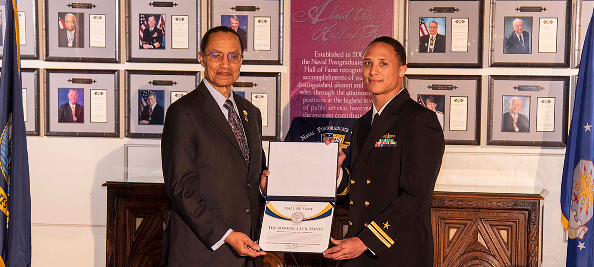 Retired U.S. Navy Adm. Cecil Haney, left, is welcomed into the NPS Hall of Fame by current NPS student U.S. Navy Lt. Dishan Romine.