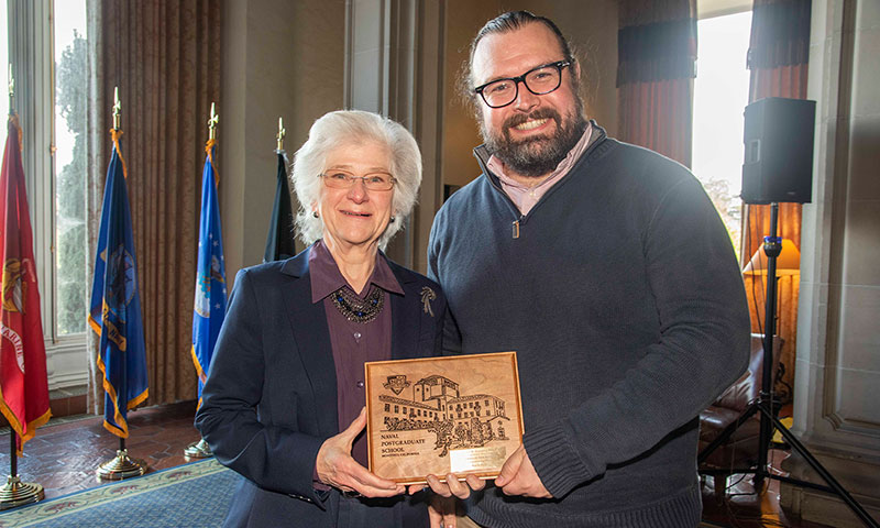 NPS President retired Vice Adm. Ann E. Rondeau presents award to Assistant Professor of Systems Engineering Douglas Van Bossuyt.